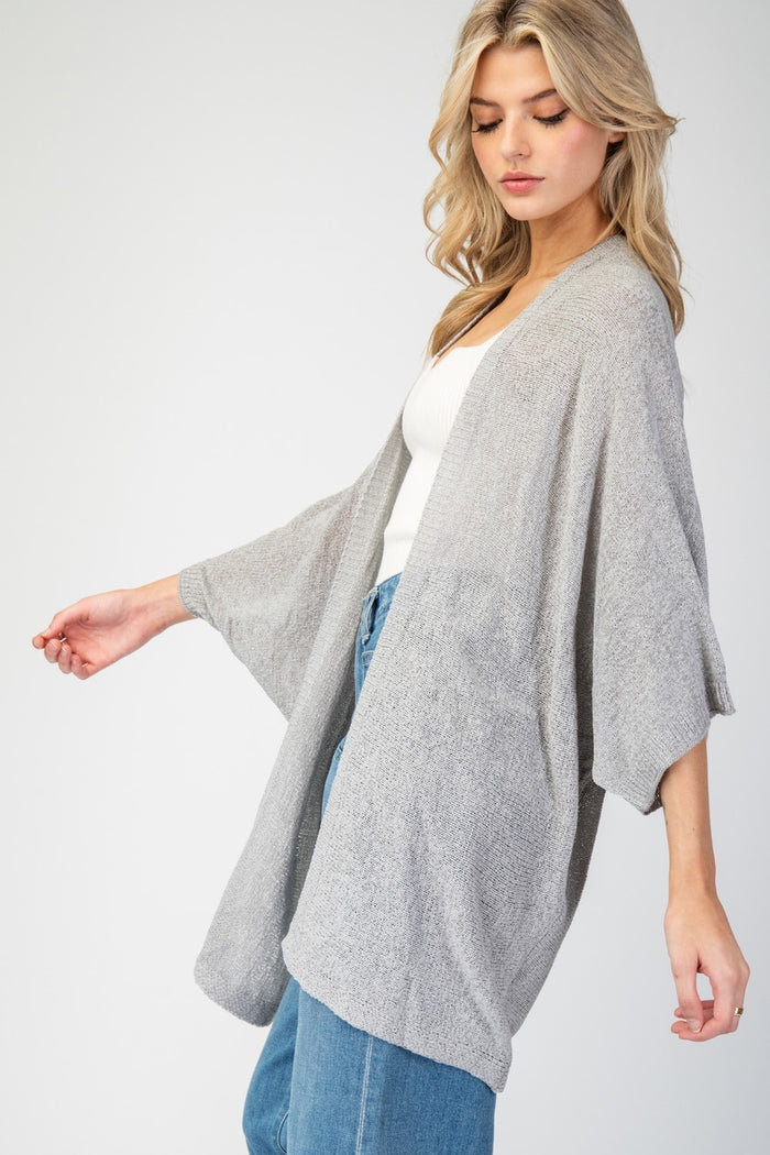 Kimono Style slouchy cardigan with short dolman sleeves made in knit fabric that's as comfy as your favorite pajamas, but way more stylish! This versatile piece drapes beautifully over any outfit, adding that perfect touch of a classic fit and look. model wearing gray with jeans