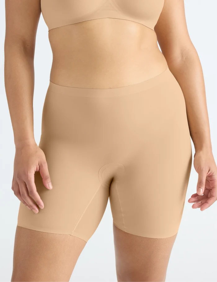 | Front view of model wearing the Leakproof Thigh Saver® 6” highlighting the coverage and smooth fit | Warm Sand