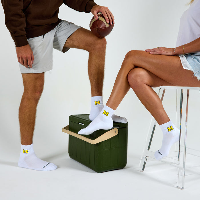 Two models wearing Del Campo Michigan Maize golf socks in studio