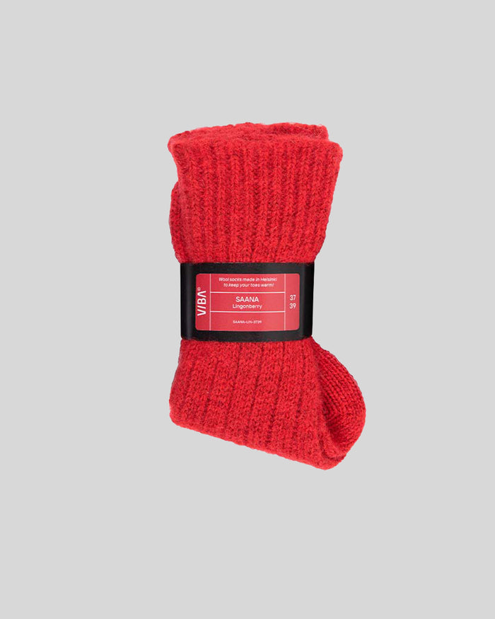 Red knitted socks with black SAANA Lingonberry label band, rolled cuff.