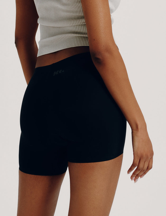 | Back view of model wearing the Teen Leakproof Shortie highlighting the coverage and smooth fit | Black