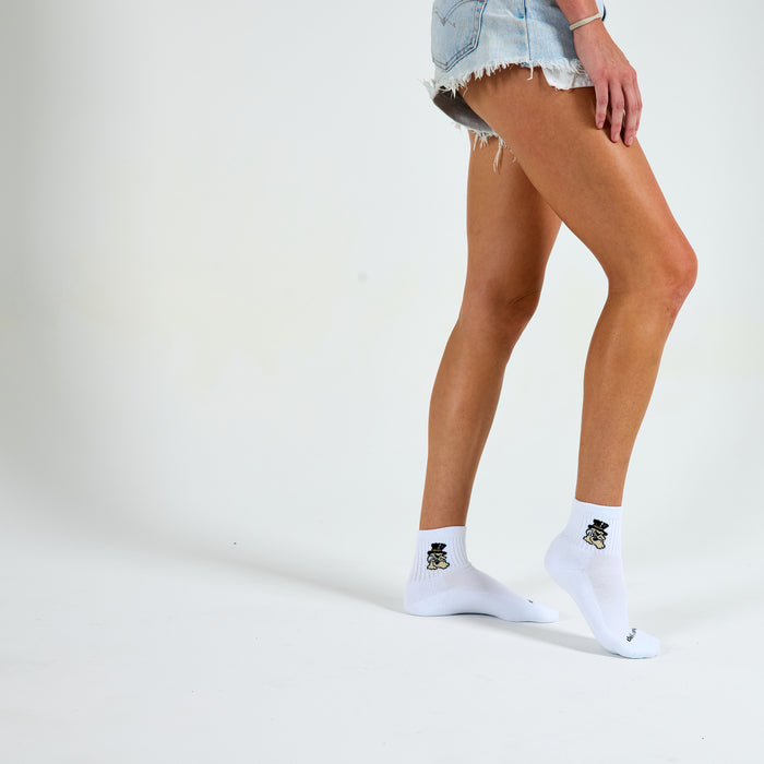 Woman wearing Del Campo Wake Forest Demon Deacons golf socks, studio shot, no shoes
