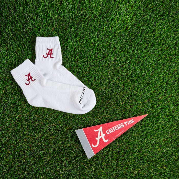 Del Campo Alabama Crimson Tide golf socks on turf with a team pennant
