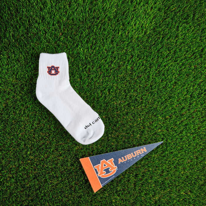 Flat lay of Del Campo Auburn War Eagle golf socks with game-day props