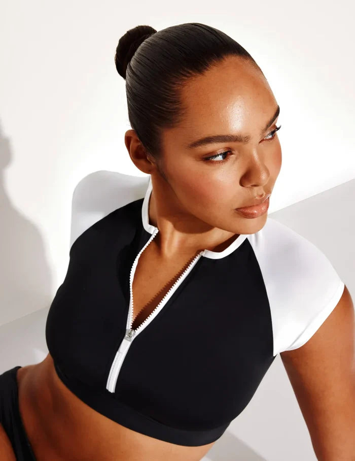 Amber is a 36C and wears a Knix size L | Front view of model wearing the Cap-Sleeve Bikini Top, highlighting the neckline, strap design, and smooth silhouette | Black/White