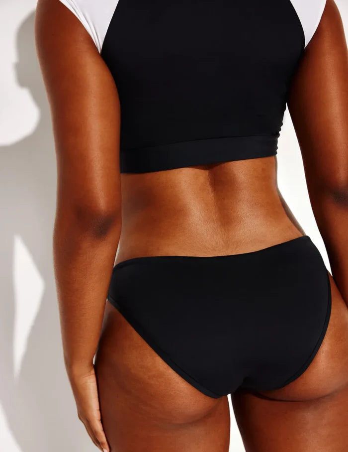 Amber is a 36C and wears a Knix size L | Back view of model wearing the Cap-Sleeve Bikini Top, highlighting the neckline, strap design, and smooth silhouette | Black/White