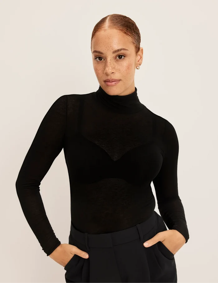 | Front view of model wearing the Cashmere Mist Turtleneck highlighting the neckline and fit | Black