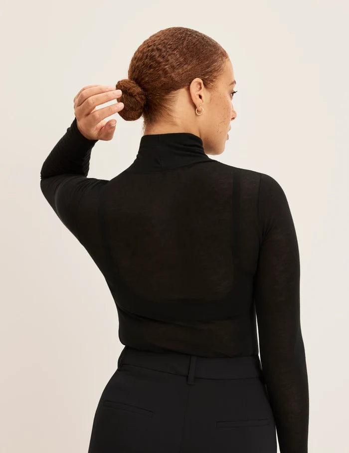 | Back view of model wearing the Cashmere Mist Turtleneck highlighting the neckline and fit | Black