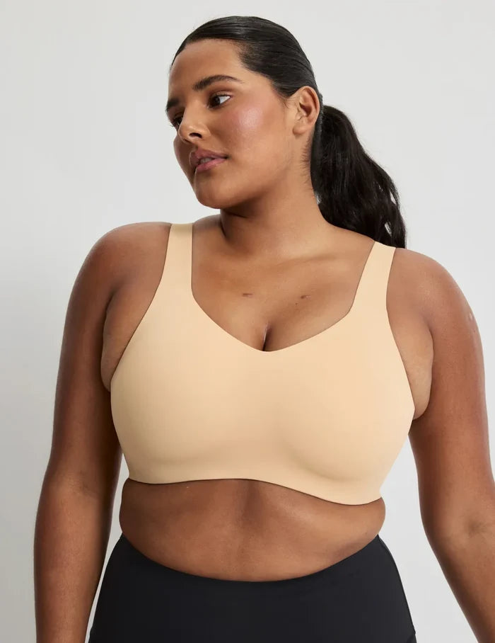 Adiya is a 36C and wearing KNIX L | Front view of model wearing the Catalyst Sports Bra, highlighting the neckline, strap design, and smooth silhouette | Warm Sand