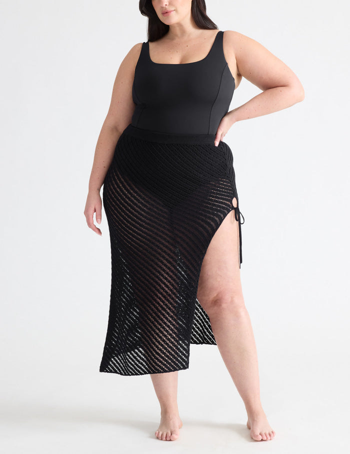 Gabrielle is a 38E, has 48" hips and wears a Knix size XL | Front view of model wearing the Crochet-Knit Beach Skirt highlighting the coverage and fit | Black