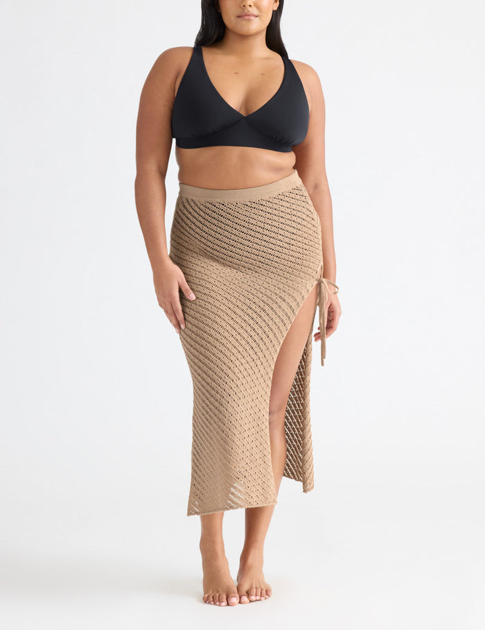 Adiya is a 36C, has 43" hips and wears a Knix size L | Front view of model wearing the Crochet-Knit Beach Skirt highlighting the coverage and fit | Taupe