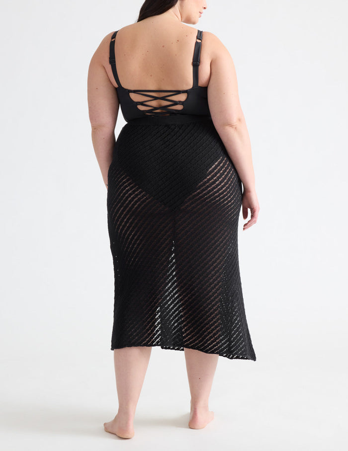 Gabrielle is a 38E, has 48" hips and wears a Knix size XL | Back view of model wearing the Crochet-Knit Beach Skirt highlighting the coverage and fit | Black