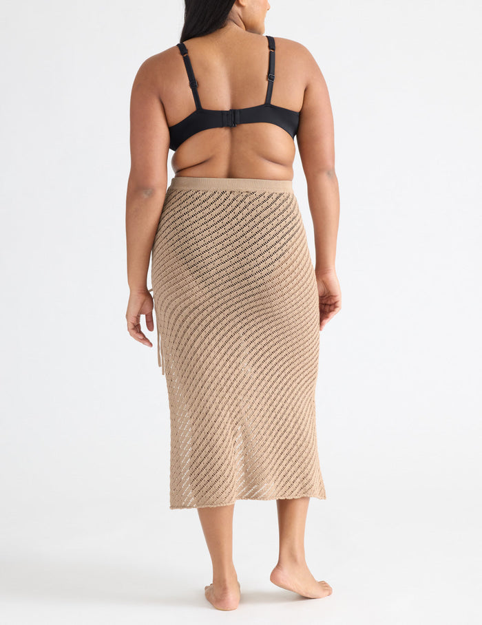 Adiya is a 36C, has 43" hips and wears a Knix size L | Back view of model wearing the Crochet-Knit Beach Skirt highlighting the coverage and fit | Taupe