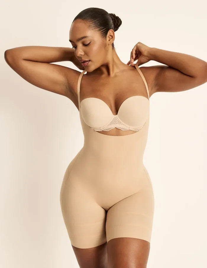 Amber is a 36C, has 46” hips, is 5’10.5” tall and wears a size L  | Front view of model wearing the Customizable Open Bust Shaper Bodysuit highlighting the coverage and smooth fit | Warm Sand