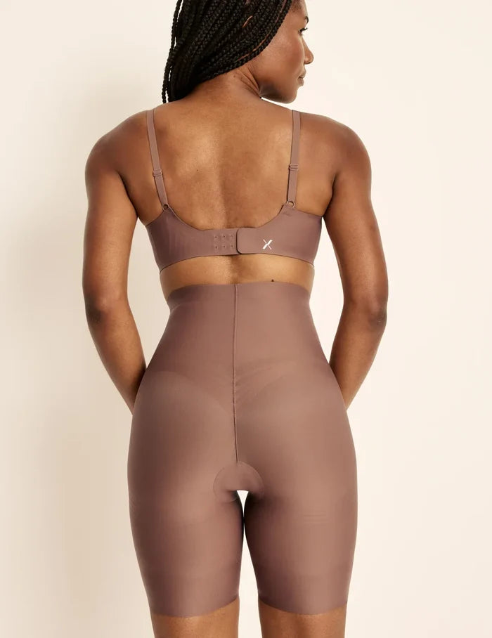 Gin has 38” hips, is 5’8” tall and wears a size S  | Back view of model wearing the Customizable Shaper High Rise Leakproof Shorts, highlighting the coverage and smooth fit | Sola