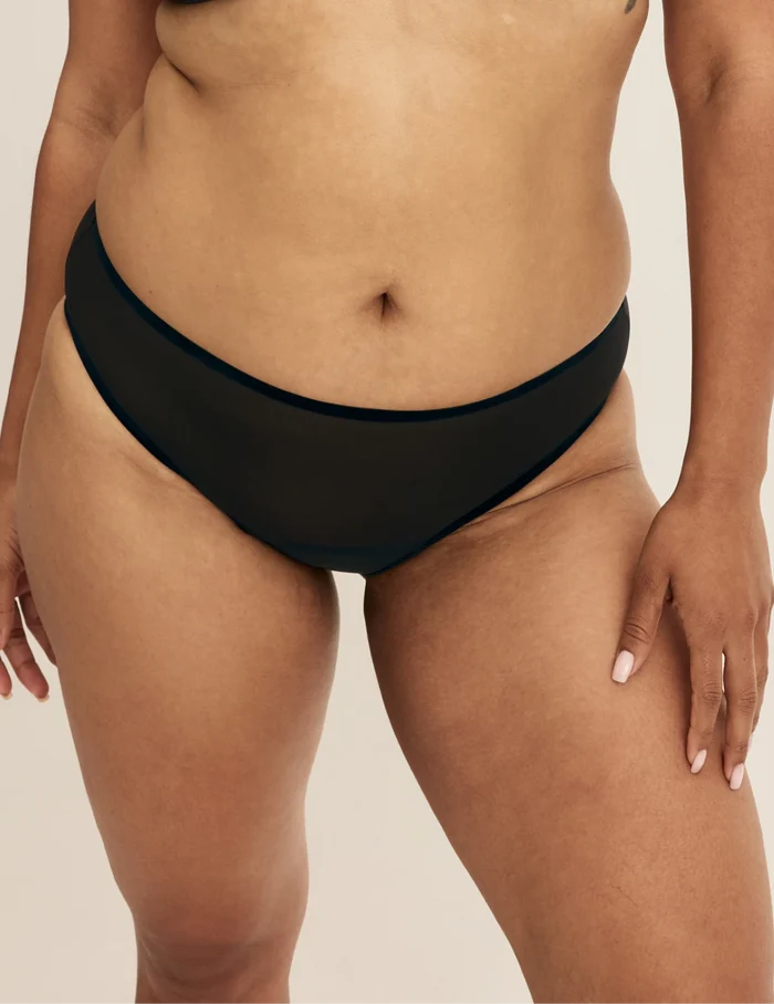 Binta has 44” hips wearing KNIX L | Front view of model wearing the Essential Full Mesh Bikini highlighting the coverage and smooth fit | Black
