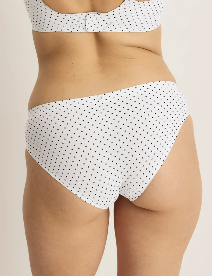 Sarah has 38.5“ hips and wears KNIX M | Back view of model wearing the Essential No-Show Bikini highlighting the coverage and smooth fit | White with Black Polka Dot