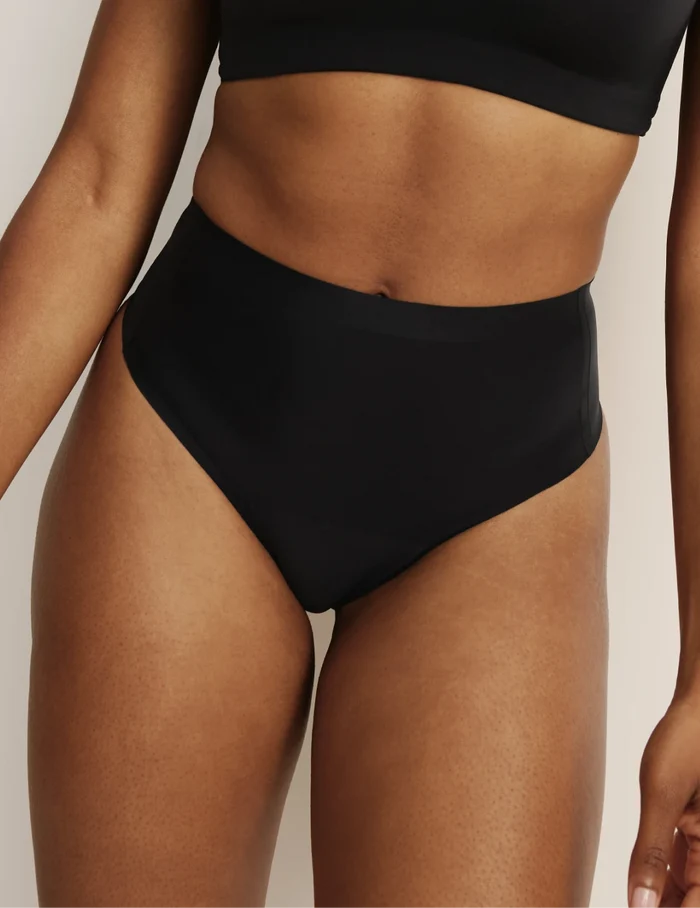 Gin has 38” hips, and wearing KNIX S | Front view of model wearing the Essential No-Show High Rise Thong highlighting the coverage and smooth fit | BlueBlack