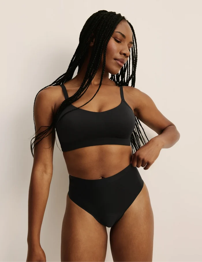 Gin has 38” hips, and wearing KNIX S | Full-body view of model wearing the Essential No-Show High Rise Thong highlighting the coverage and smooth fit | BlueBlack