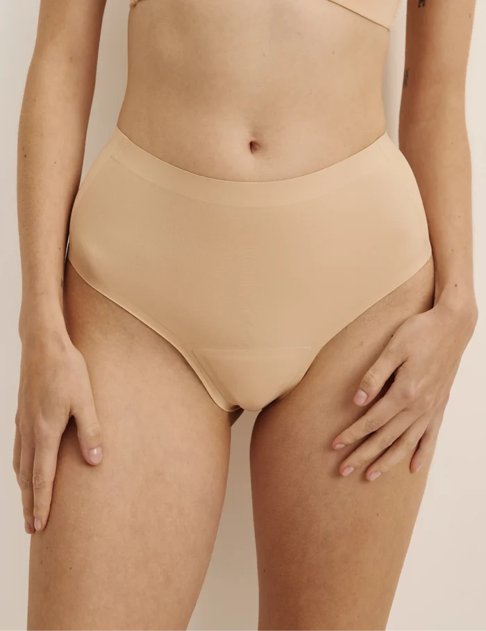 Molly has 36“ hips wearing KNIX S | Front view of model wearing the Essential No-Show High Rise Thong highlighting the coverage and smooth fit | Warm Sand