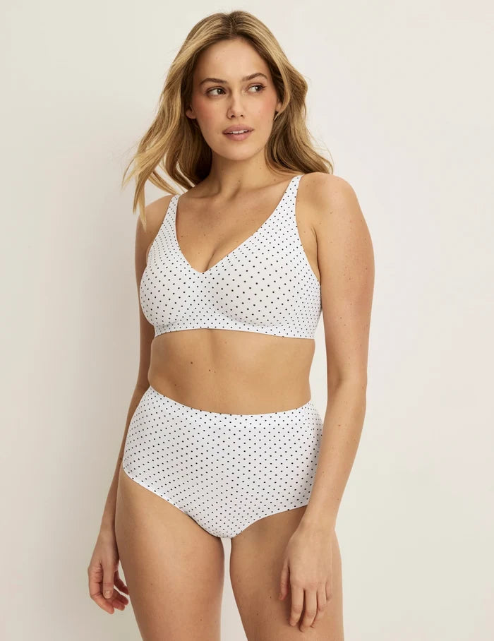 Sarah has 38.5“ hips and wears KNIX M | Full-body view of model wearing the Essential No-Show High Rise highlighting the coverage and smooth fit | White with Black Polka Dot