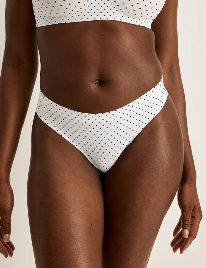 | Front view of model wearing the Essential No-Show Thong highlighting the coverage and smooth fit | White with Black Polka Dot