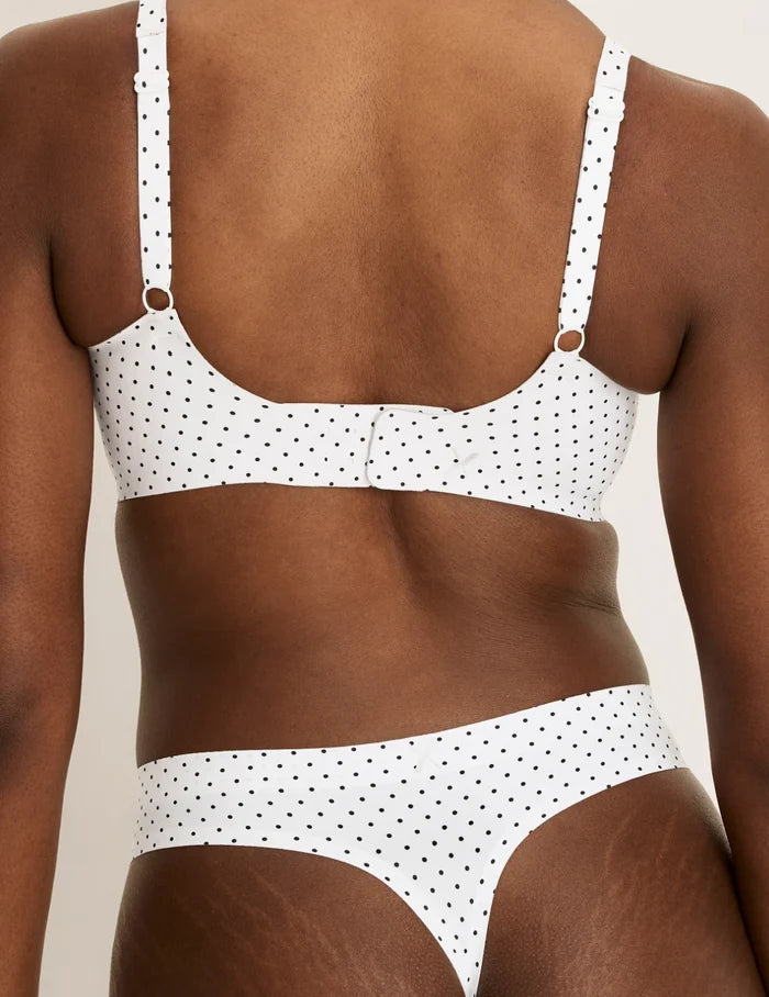 | Front view of model wearing the Essential No-Show Thong highlighting the coverage and smooth fit | White with Black Polka Dot