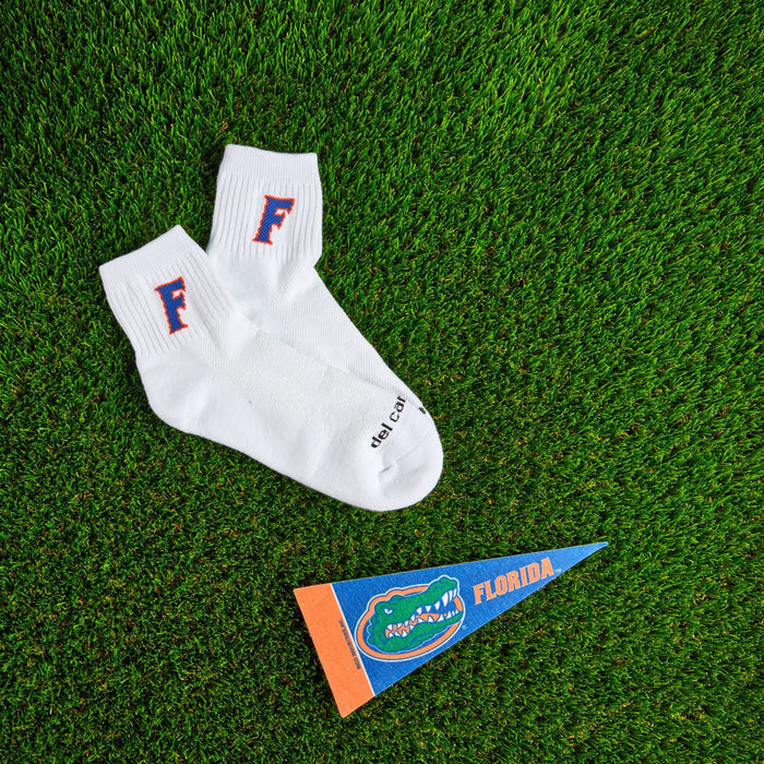 Del Campo Florida Gators Block F golf socks on turf with a team pennant
