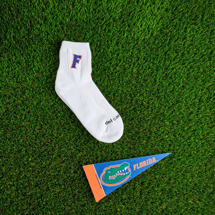 Flat lay of Del Campo Florida Gators Block F golf socks with game-day props