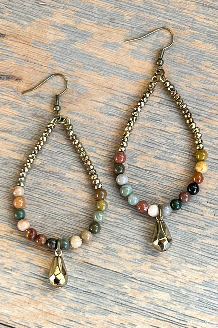 Fishhook beaded, teardrop shaped hoop earrings with a small gold dangle bead. Lightweight. Feature African Turquoise stone and gold crystal beads. Length: 3"