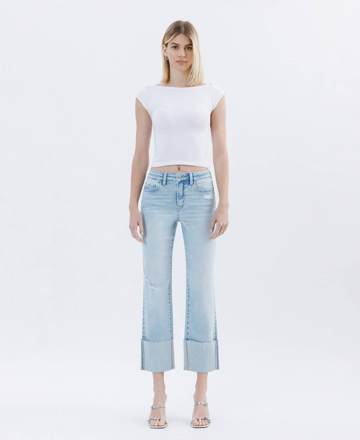 Highrise cuffed crop straight jeans. comfort stretch denim, high-rise wait distressed detail, single cuff hem cropped length straight 
model is standing alone wearing a 27 inh insem with pumps