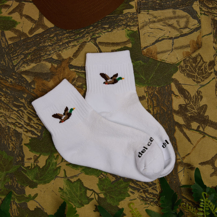 Pair of Del Campo Mallard socks on camo fabric with a hat