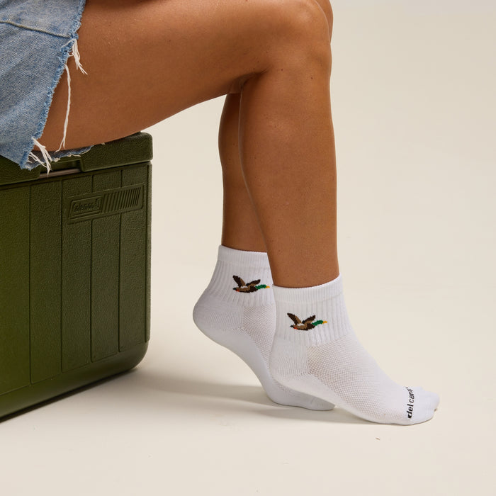Del Campo Mallard socks worn beside a green cooler and golf ball