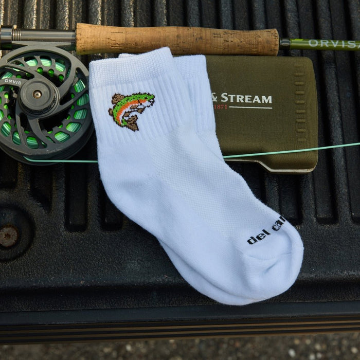 Del Campo Trout sock on a truck bed beside a fly reel and Field & Stream box
