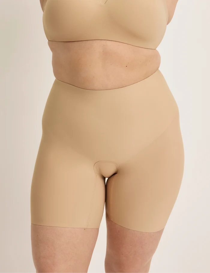 Beatrice is wearing KNIX XL | Front view of model wearing the Leakproof Contour Thigh Saver® 6”, highlighting the coverage and smooth fit | Warm Sand