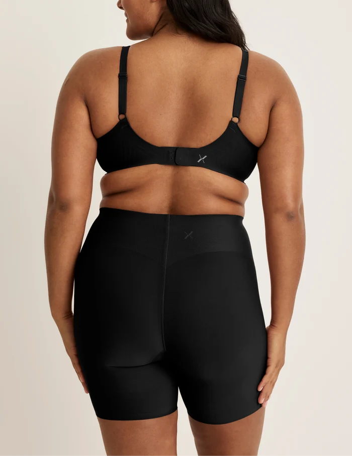 Adiya is wearing KNIX L | Back view of model wearing the Leakproof Contour Thigh Saver® 6”, highlighting the coverage and smooth fit | Black