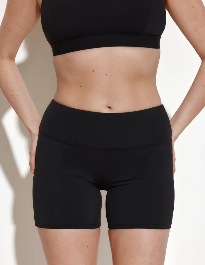 | Front view of model wearing the Leakproof Sculpt Long Swim Short highlighting the coverage and fit | Black