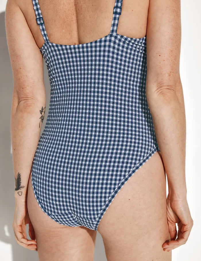 | Back view of model wearing the Leakproof Seersucker Sculpt Deep V One Piece Swimsuit highlighting the neckline, coverage and fit | Navy Seersucker
