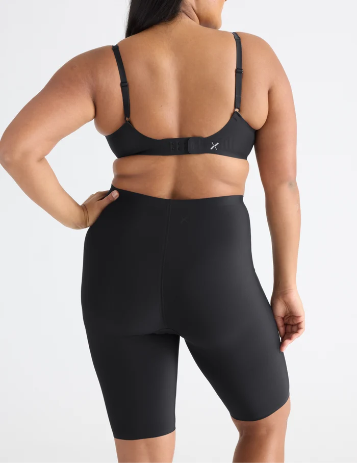 Adiya is wearing KNIX L | Back view of model wearing the Leakproof Thigh Saver® 10”, highlighting the coverage and smooth fit | Black