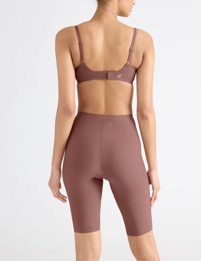 | Back view of model wearing the Leakproof Thigh Saver® 10”, highlighting the coverage and smooth fit | Sola