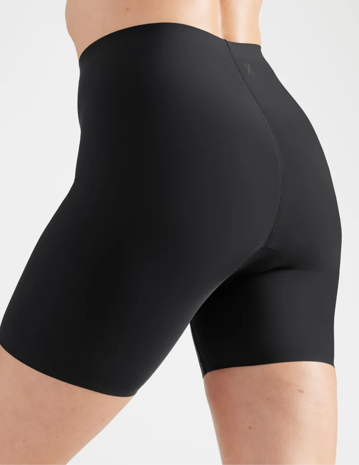 | Side view of model wearing the Leakproof Thigh Saver® 6” highlighting the coverage and smooth fit | Black
