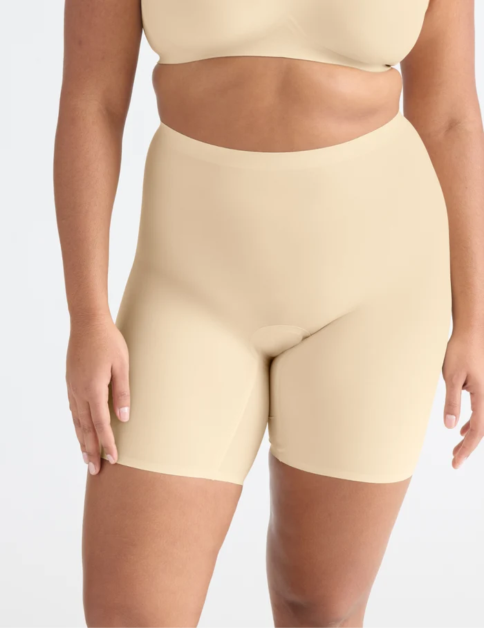 | Front view of model wearing the Leakproof Thigh Saver® 6” highlighting the coverage and smooth fit | Dune