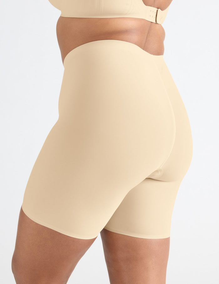 | Side view of model wearing the Leakproof Thigh Saver® 6” highlighting the coverage and smooth fit | Dune