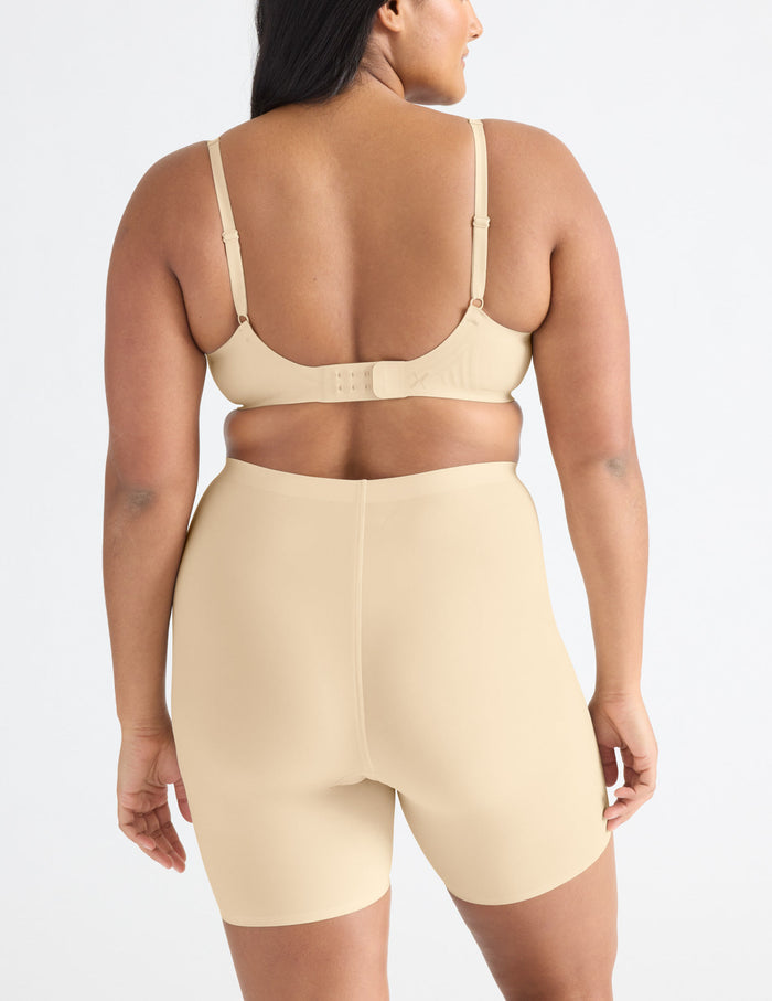 | Back view of model wearing the Leakproof Thigh Saver® 6” highlighting the coverage and smooth fit | Dune