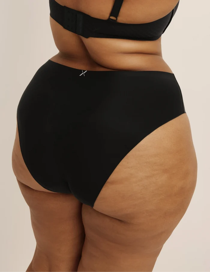 Leslie has 49” hips and wearing KNIX XXL | Back view of model wearing the Leakproof UltraThin No-Show French Cut highlighting the coverage and smooth fit | Black