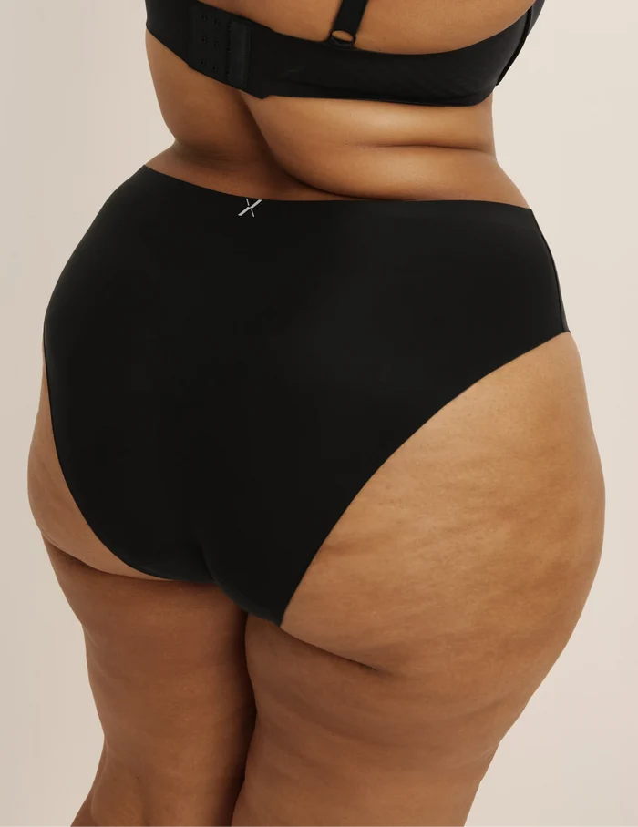 Leslie has 49” hips and wears KNIX XXL | Back view of model wearing the Light Leakproof No-Show French Cut highlighting the coverage and smooth fit | Black