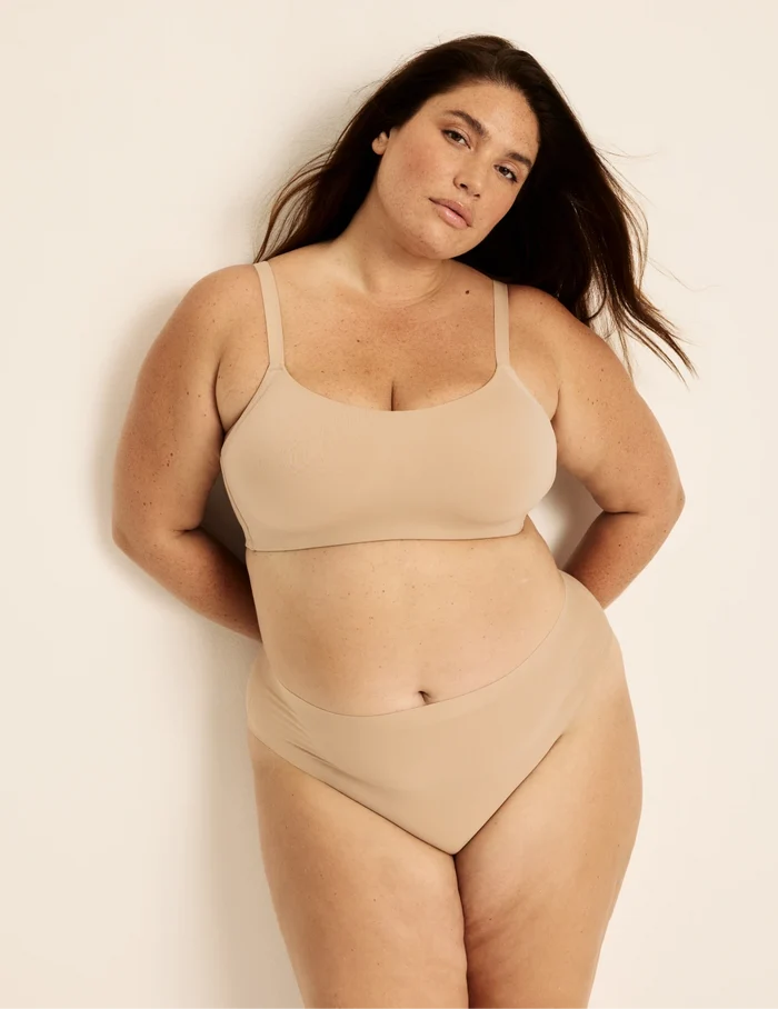 Clementine has 51” hips, and wearing KNIX XXL | Full-body view of model wearing the Light Leakproof No-Show French Cut highlighting the coverage and smooth fit | Warm Sand