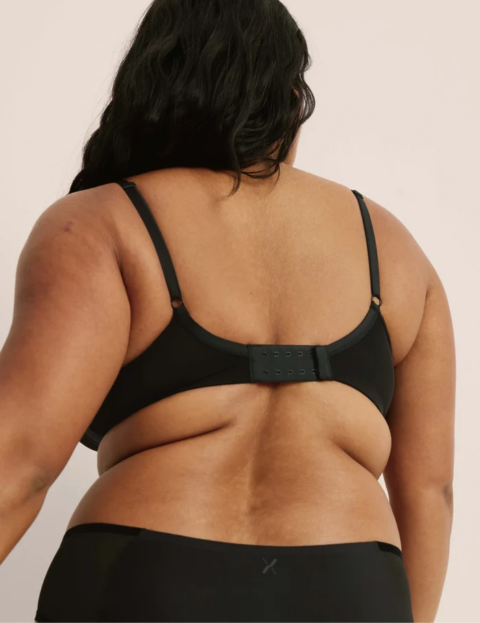 Adiya is a 36C and wearing KNIX L  | Back view of model wearing the Mesh Deep V Bra, highlighting the neckline, strap design, and smooth silhouette | Black