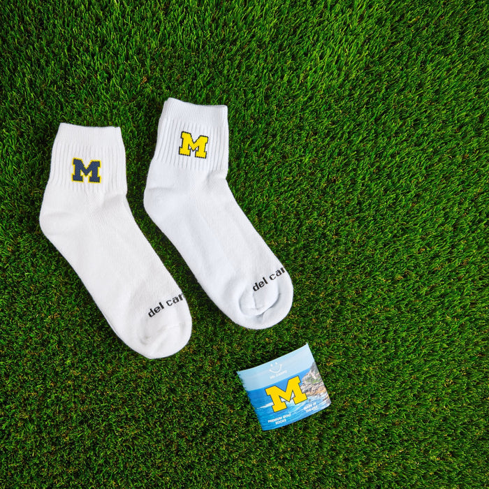 Flat lay of Del Campo Michigan Maize golf socks with game-day props