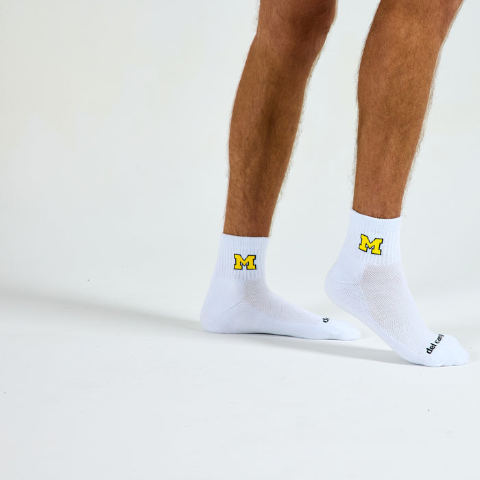 Man wearing Del Campo Michigan Maize golf socks, studio shot, no shoes